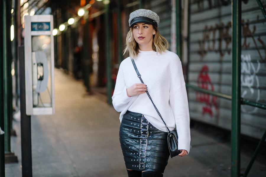 NYC Blogger, Rebecca Minkoff crossbody, Over the knee black boots, newsboy cap, pay phone, Hells Kitchen NYC, white sweater, chic fall fashion, fall outfit, white and black outfit, edgy fashion, misguided leather skirt