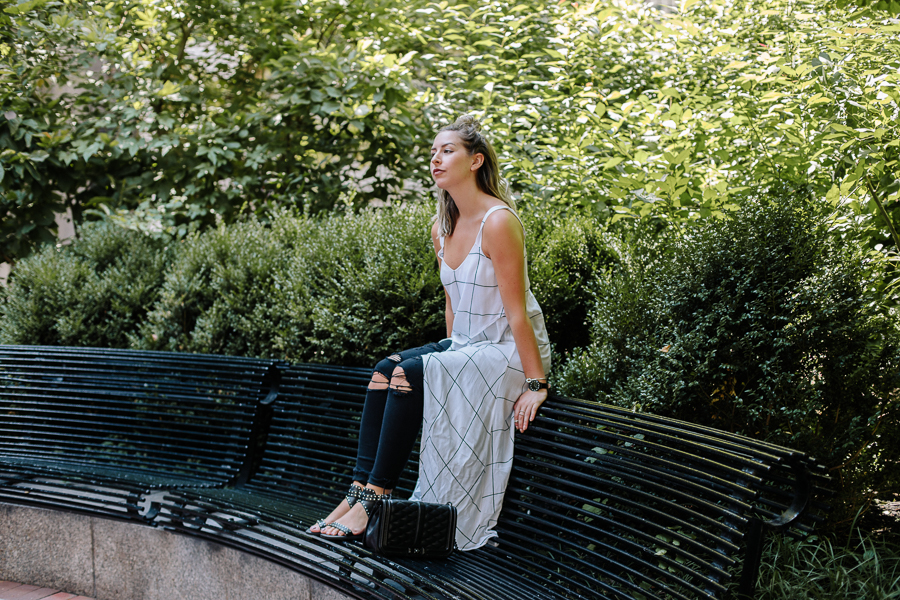 Boston Blogger, NYC Blogger, Boston Financial District, White Asymmetrical Tank Top, Leith Tank Top, Wrap Top, Half Up Top Knot, Black Jeans, sitting on park bench, black studded sandals